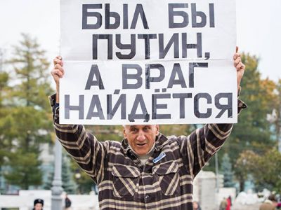 Активист Владимир Ионов с плакатом: "Был бы Путин, а враг найдется". Фото: Alexander Makarov / News-sirotin.com
